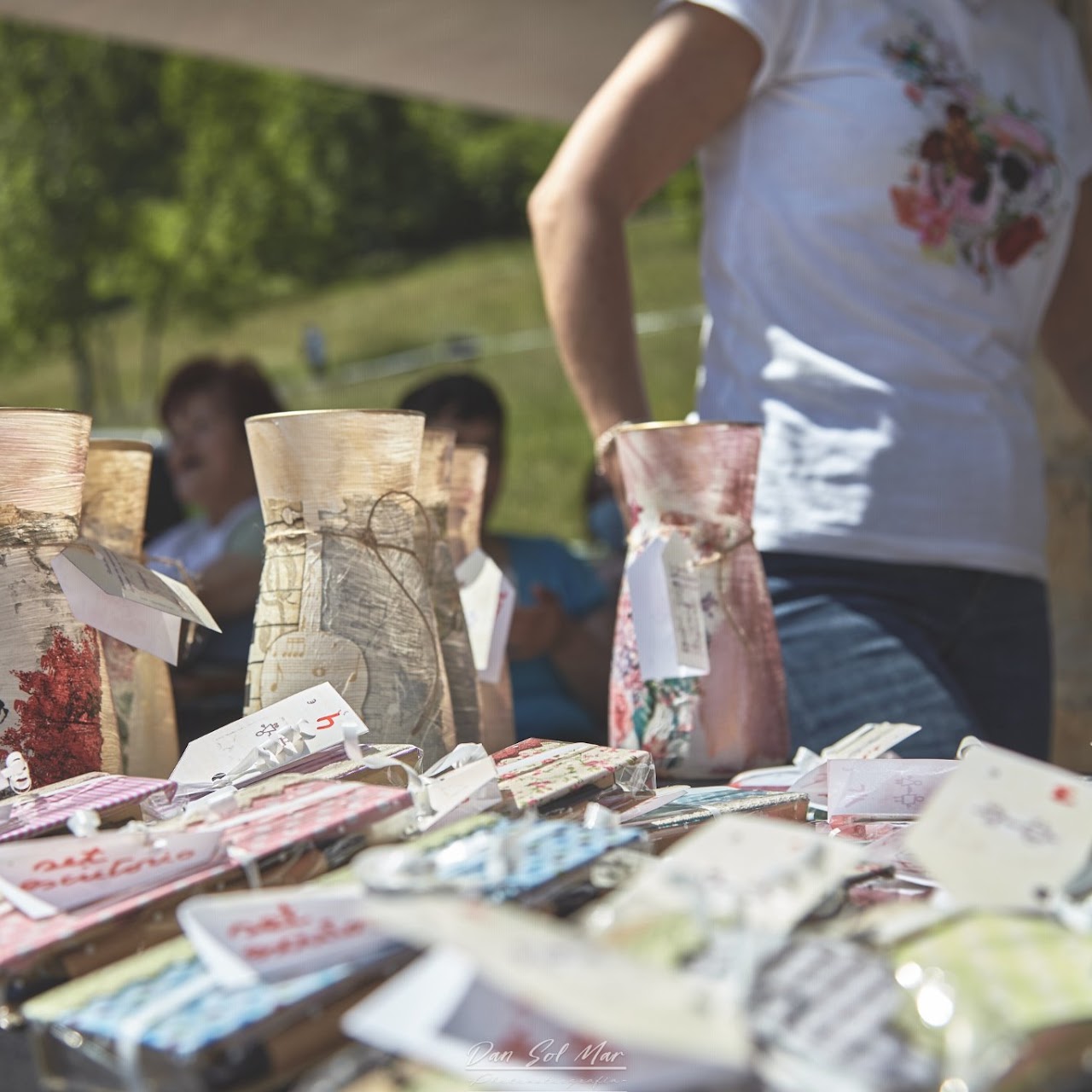 Mesa de mercadillo con jarrones decorados a mano y pequeños regalos envueltos y etiquetados